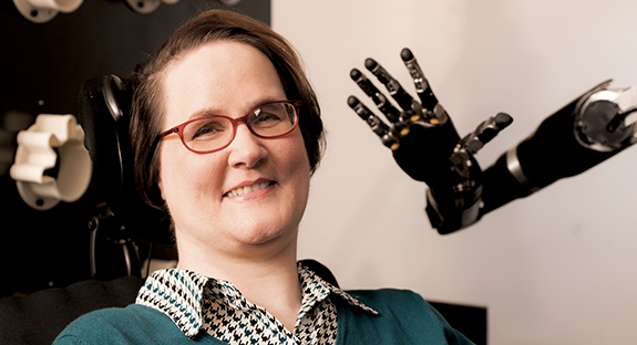 A brain-computer interface has enabled Jan Scheuermann, who has quadriplegia, to control a robotic arm with her mind.