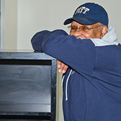 John Wilds, assistant vice chancellor for community relations, helps move shelving in the Oakland Community Food Pantry on Lawn Street.