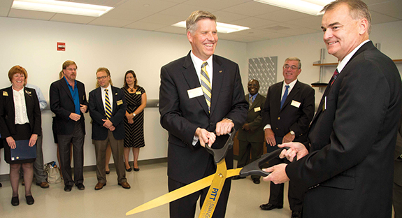 Pitt and Lubrizol Corp. officials participated in an Aug. 12 ribbon-cutting ceremony at the new Lubrizol Innovation Lab in Benedum Hall. In the background are Provost and Senior Vice Chancellor Patricia E. Beeson, on far left, and Gerald D. Holder, U.S. Steel Dean of Engineering, on far right. Holding the scissors, from left, are Pitt Chancellor Patrick Gallagher and Michael Vaughn, Lubrizol’s corporate vice president of operations.