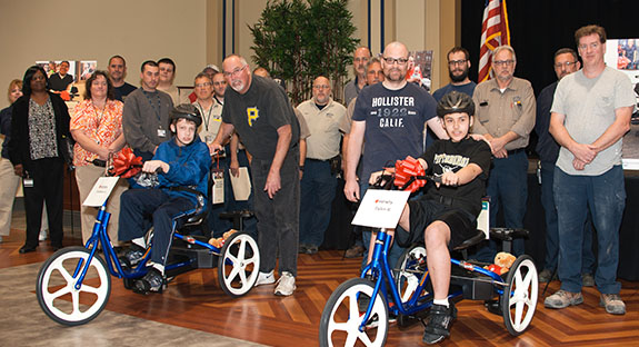 Pitt employees contributed about $5,400 to buy three adaptive bicycles for local children with special needs. Contributing staffers from Pitt’s Department of Housing, Food Services, and Panther Central gathered May 3 in the William Pitt Union Assembly Room as the children—two of whom are pictured here—received their bikes. The three-wheelers had been adapted to each child’s needs through the “My Bike” Program, part of Variety-the Children’s Charity, which has provided more than 1,000 bikes for eligible youngsters in 50 Pennsylvania counties since 2012. (Photo by Emily O'Donnell)