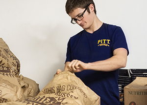 Patrick Callaghan, a volunteer from Pitt’s Student Dietetic Association, inspects deliveries of potatoes.