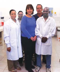 Pitt researchers Deborah McMahon and Lee Harrison visit a laboratory supervisor and technicians in the Catholic University of Mozambique’s (UCM) Infectious Diseases Research Center in Beira, Mozambique. McMahon (front row, center), a Pitt professor of medicine and of infectious diseases and microbiology, is the project director for Beira’s Twinning Center, an HIV-focused health center where Pitt and UCM faculty train local health care workers in primary HIV care. Harrison, (back row, far right), a Pitt professor of medicine, epidemiology, and infectious diseases and microbiology, has helped train scores of Brazilian HIV researchers over the past 12 years. He and McMahon are discussing how U.S. and Brazilian researchers could train their Mozambique counterparts through an HIV research training program funded by the National Institutes of Health Fogarty International Center.