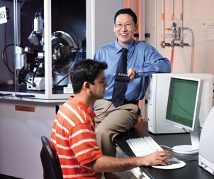 Part of the nanoscience research being done by Di Gao, a Pitt assistant professor of chemical and petroleum engineering and a W. K. Whiteford Faculty Fellow, is discovering how nanoparticles can be used to prevent ice buildup on road surfaces as well as on airplane wings and power lines. Here, Gao works with Ashish Yeri, a fourth-year PhD student. The large machine in the background is an X-ray diffractometer, which is used to examine the crystallinity of materials.  