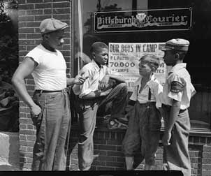Four paperboys stand outside The Pittsburgh Courier offices on Centre Avenue; photo by Charles "Teenie" Harris.
