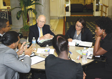 J. Roger Glunt (center), an emeritus trustee on Pitt’s Board of Trustees, works with a group of students during the Hesselbein Academy Summit. Glunt was one of nine professional mentors who delivered presentations on various leadership topics and worked personally with students during the four-day summit.