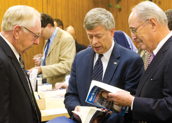 From left, University Library System (ULS) Director Rush Miller, Pitt Chancellor Mark A. Nordenberg, and Dick Thornburg inspect Thornburgh's book, Where the Evidence Leads, which was printed in about seven minutes from a digital file.