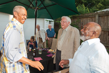 CELEBRATING WITH THADDEUS MOSLEY:  Friends and families celebrated Thaddeus Mosley’s (A&S ’50) “near 85 years of energetic life” during a June 11 outdoor party at the Highland Park home of Terry Seya (KGSB ’93). Mosley (far right) is a prominent and nationally known sculptor, based in Pittsburgh, who works primarily in wood. He is talking with Davis Lewis (center, front), an architect, writer, painter, and longtime friend, and Robert Hill (far left), Pitt’s vice chancellor for public affairs. Lewis is the author of Thaddeus Mosley: African-American Sculptor (University of Pittsburgh Press, 1997). 
