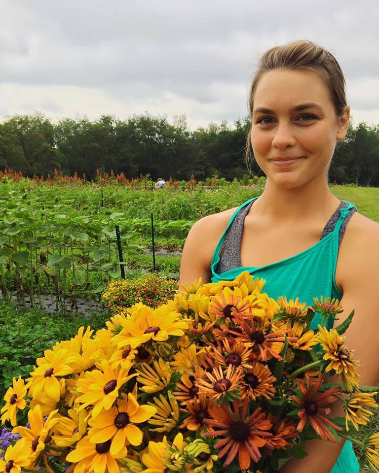 a young woman holding a bouquet of flowers