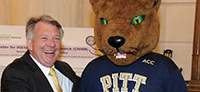State Sen. John N. Wozniak (UPJ ’78) shakes hands with Roc, the Pitt Panther mascot.