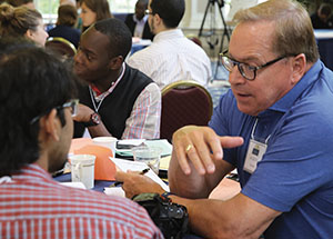 Keith Schaefer, executive chairman of City Paper Box and a Pitt trustee, also mentors a student during one of the summit’s work sessions.