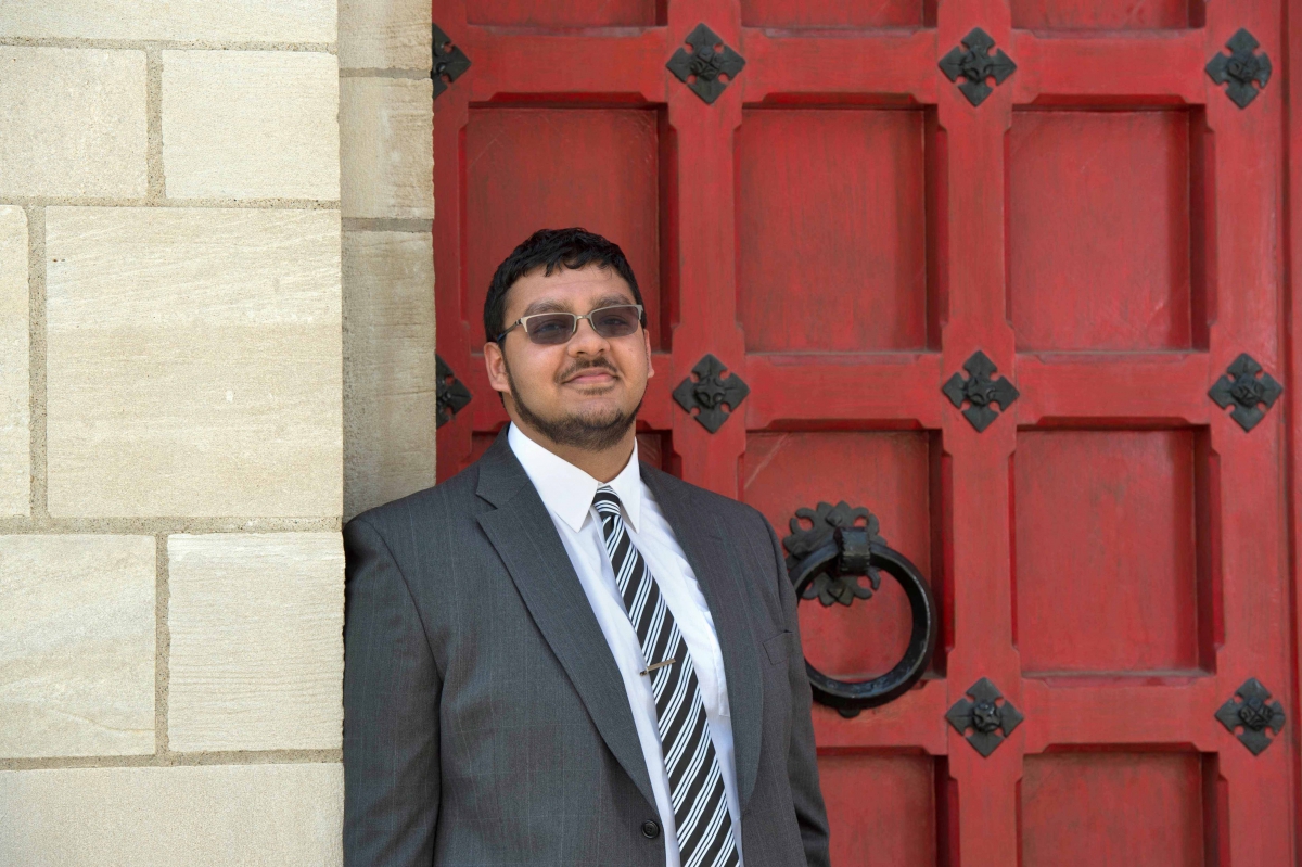 Kaleem in front of a red door