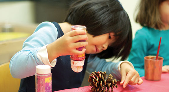 With careful thought and precision, Madisen Wu placed glitter on a pine cone and observed the shiny specks fall. She and her classmates in Pitt’s University Child Development Center prepared seasonal crafts to share with Pitt Chancellor Patrick Gallagher and his family at their residence near campus. At press time, two groups of 17 preschoolers each were scheduled to walk to the Gallaghers’ home and adorn the trees within. No doubt, a fun winter adventure for all. (Photo by Emily O'Donnell)