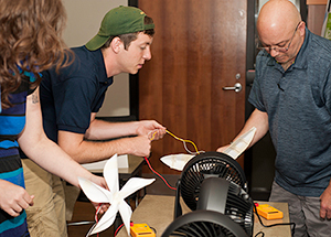 Christopher Kastronis (right), an eighth grade science teacher at Founders Hall Middle School, McKeesport, tests his paper wind turbine during a recent Mascaro Center sustainability workshop. He is assisted by Cameron Beichner, a Pitt mechanical engineering undergraduate. (Photos by Emily O'Donnell)