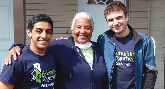 Students helped a homeowner (center) on Ward Street, South Oakland, make repairs to her home.