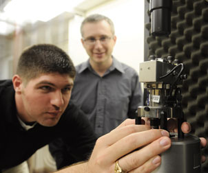 Alexander Star (background), an assistant professor of chemistry in Pitt's School of Arts & Sciences, is working with other researchers in his lab to turn nanotubes into chemical and biological sensors. His research group recently used tubes with diameters 100,000 times smaller than a human hair to develop a sensor that can warn asthma sufferers of an impending attack. Here, Brett Allen, who recently completed his doctoral degree in chemistry under Star’s supervision, uses an atomic force microscope to visualize carbon nanotubes.