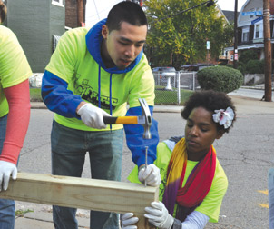 Volunteers construct a planter bench in the South Oakland community garden known as Frazier Farms. 