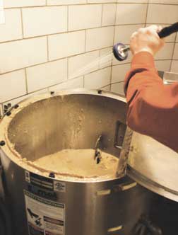 Tod Shoenberger, unit manager for Sodexo, rinses the inside of the pulper, and industrial-size blender that grinds food and other organic matter into a slurry. In October, Shoenberger used the resulting compost on his home rose garden with excellent results, he said.