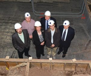 Officials from the National Institute of Standards and Technology (NIST) toured first-phase renovations for a state-of-the-art laboratory in the Nuclear Physics Laboratory (NPL) Oct. 6. The site, dug four feet lower than the previous basement floor, is being prepared to house two acoustically isolated experimental chambers for research conducted by physics and astronomy professor Jeremy Levy and his colleagues. These experimental chambers will provide Levy with an environment isolated from stray noises and extraneous radio frequencies, allowing researchers to look at materials that show promise for quantum computing. The construction, along with two other projects, is being funded through a $32 million grant from NIST, which has funneled monies from the 2009 American Recovery and Reinvestment Act into research and technology initiatives. Levy’s project completion date is slotted for summer 2012, while the additional laboratories will be built by spring 2014. When finished, there will be 75,000 square feet of new lab space in Allen Hall, NPL, and Old Engineering Hall, as well as an interdisciplinary machine shop. Front row, from left: David Turnshek, chair of Pitt’s Department of Physics and Astronomy; Patricia E. Beeson, Pitt provost and senior vice chancellor; Levy; and George Klinzing, Pitt vice provost for research and principal investigator for the NIST program. Back row, from left: Michael Diestel, NIST program officer; and N. John Cooper, Pitt’s Bettye J. and Ralph E. Bailey Dean of Arts and Sciences. 