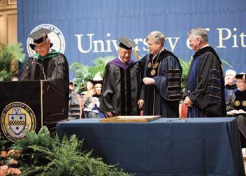  Joseph F. Weis Jr. (LAW ’50), senior judge of the U.S. Court of Appeals for the Third Circuit, prepares to receive a plaque recognizing him as a 2011 Distinguished Alumni Fellow. From left, Pitt Alumni Association President Jack Smith (at lecturn), Weis, Chancellor Mark A. Nordenberg, and Pitt Board of Trustees Chair Stephen R. Tritch. 